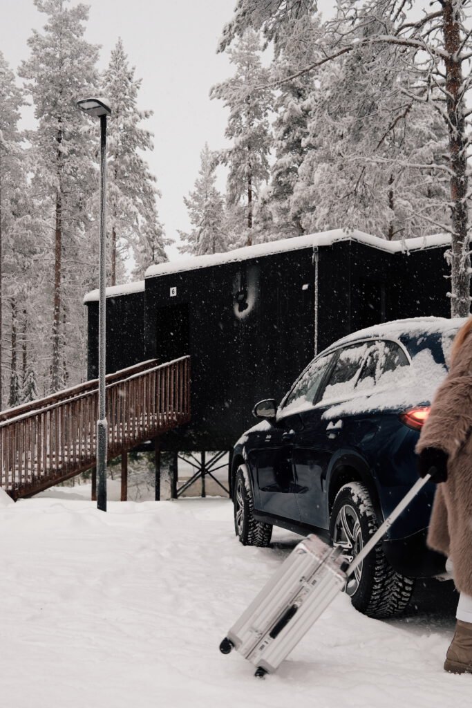 Guest arriving at NOA Villas with luggage beside a snow-covered villa.