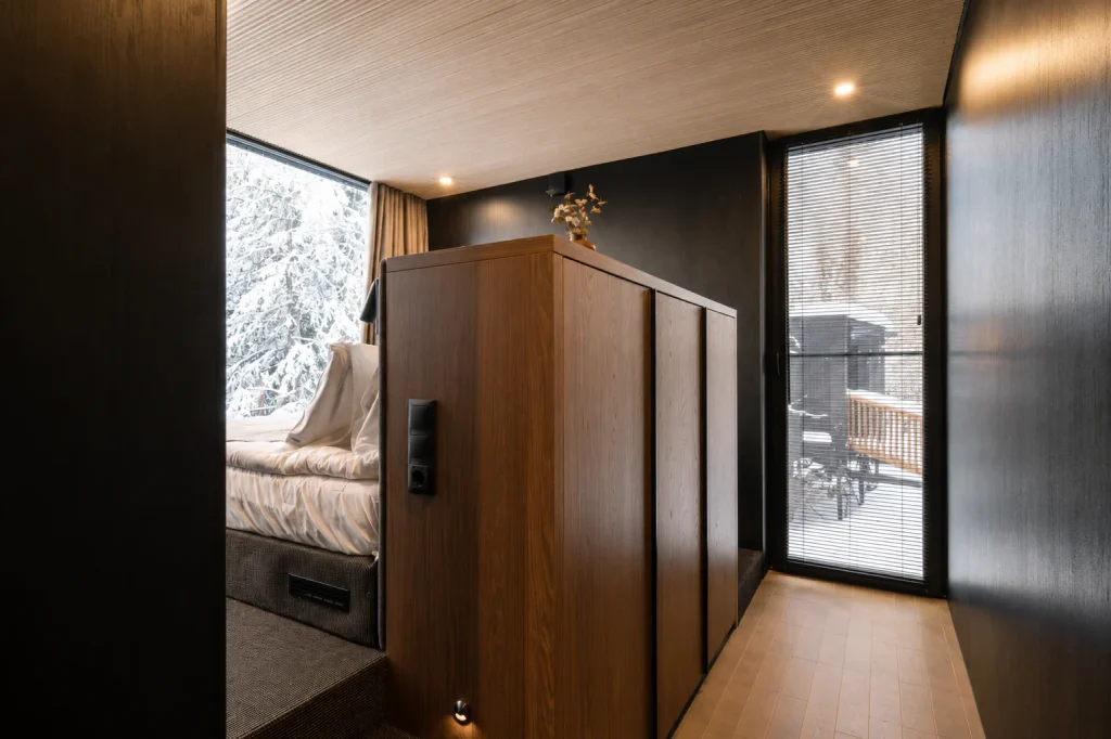 Deluxe Villa bedroom with large windows overlooking the winter forest and private terrace.