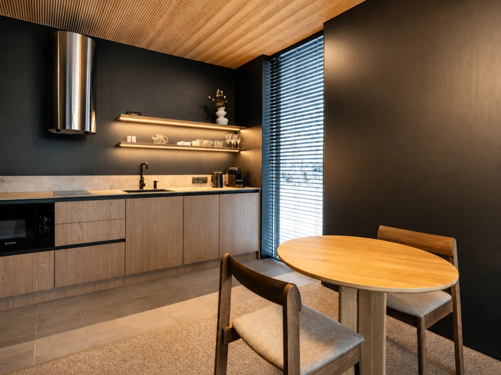 Deluxe Villa kitchen and dining area with timber cabinetry and snowy forest views.