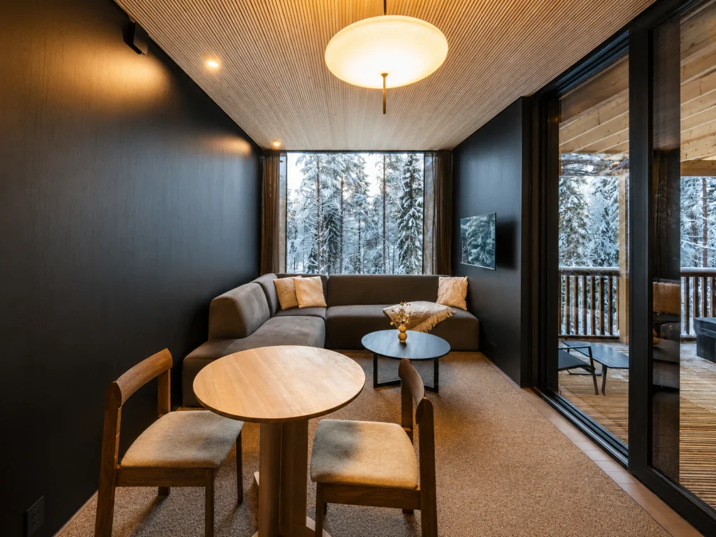 Deluxe Villa living room with lounge seating, a dining table and forest views.
