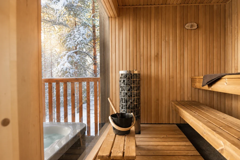 Timber-lined private sauna inside the Deluxe Villa beside its outdoor hot tub.