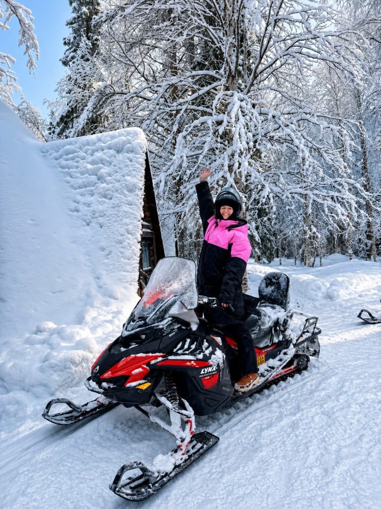 Guest on a snowmobile during a winter safari in Lapland.