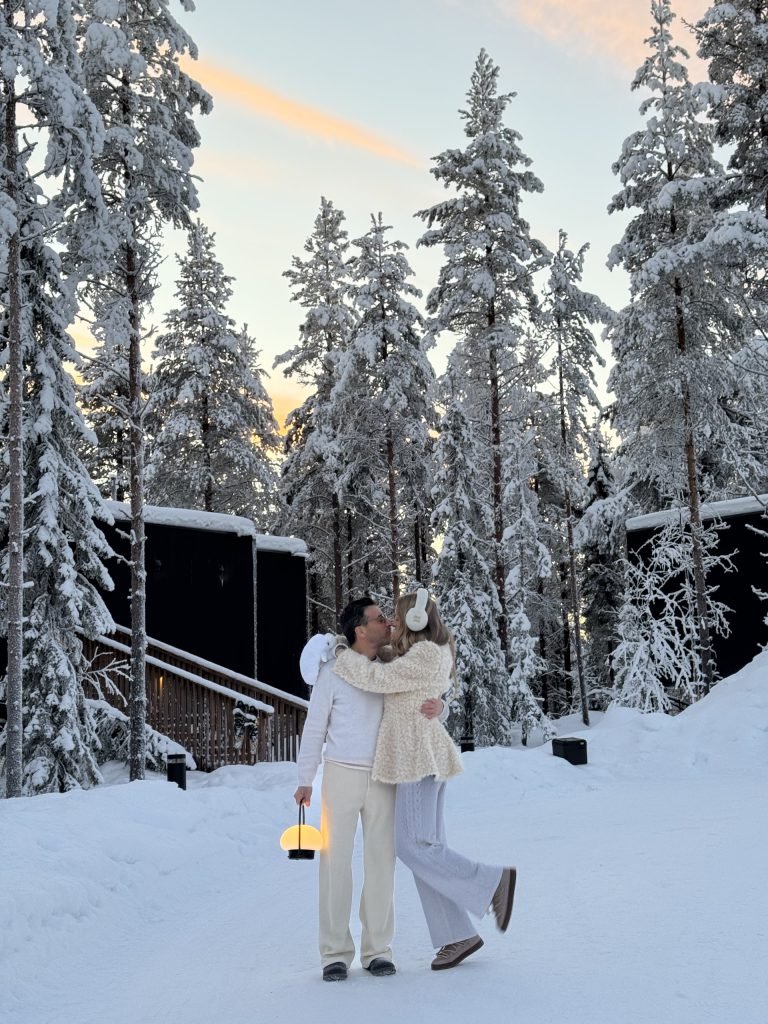 Couple sharing a winter moment between NOA Villas in snowy Lapland.