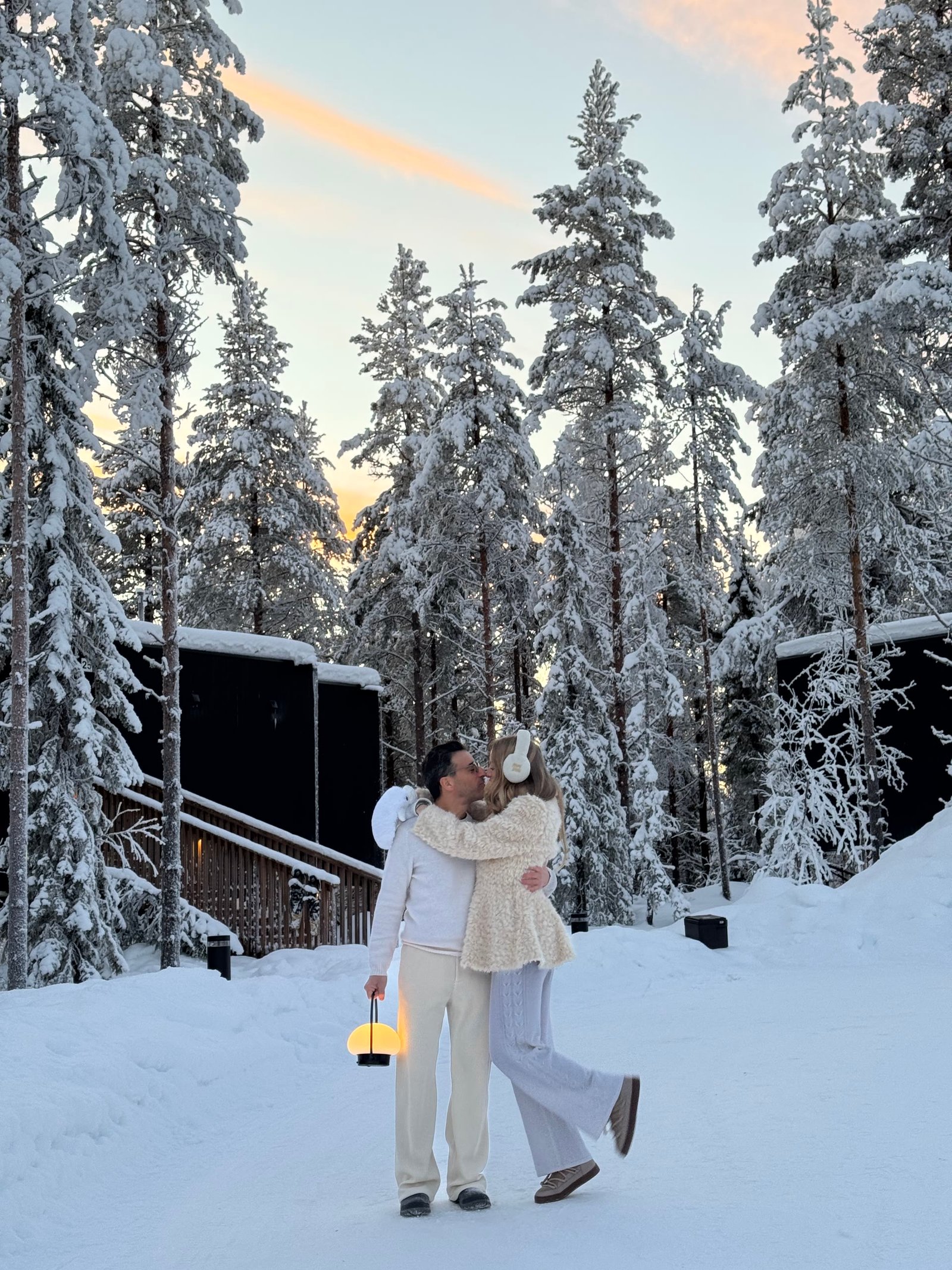 Couple sharing a winter moment between NOA Villas in snowy Lapland.