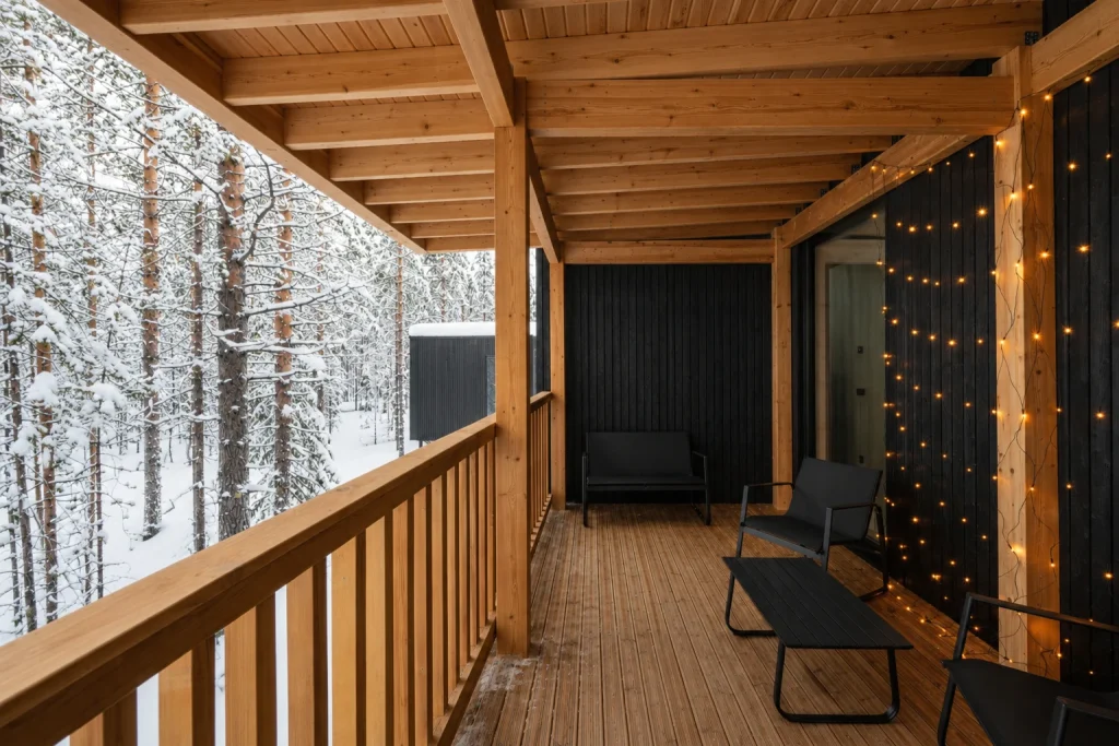 Covered Standard Villa terrace overlooking snow-covered pine trees in Finnish Lapland.