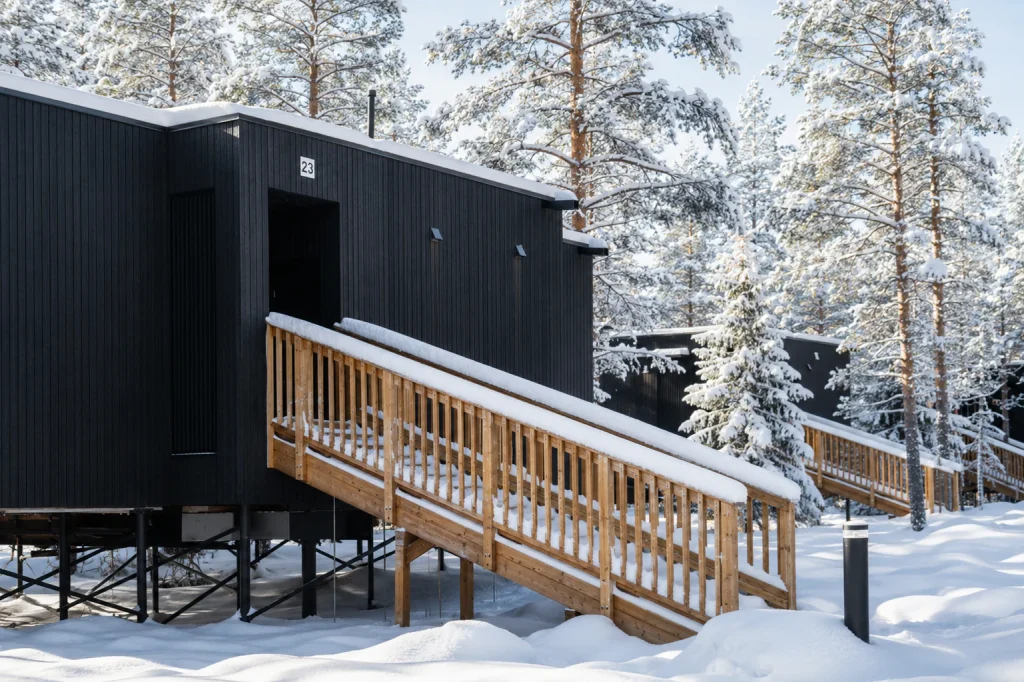 Superior Villa entrance and timber walkway in a snowy Lapland forest.