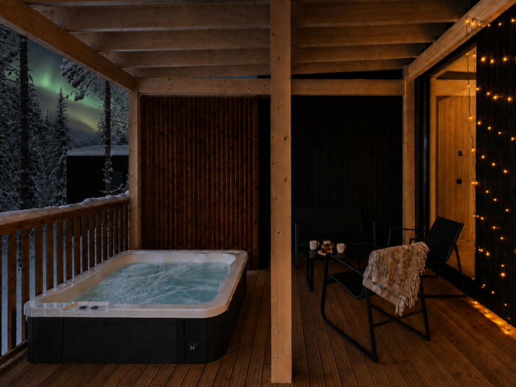 Private outdoor hot tub on the covered Superior Villa terrace overlooking the snowy forest.